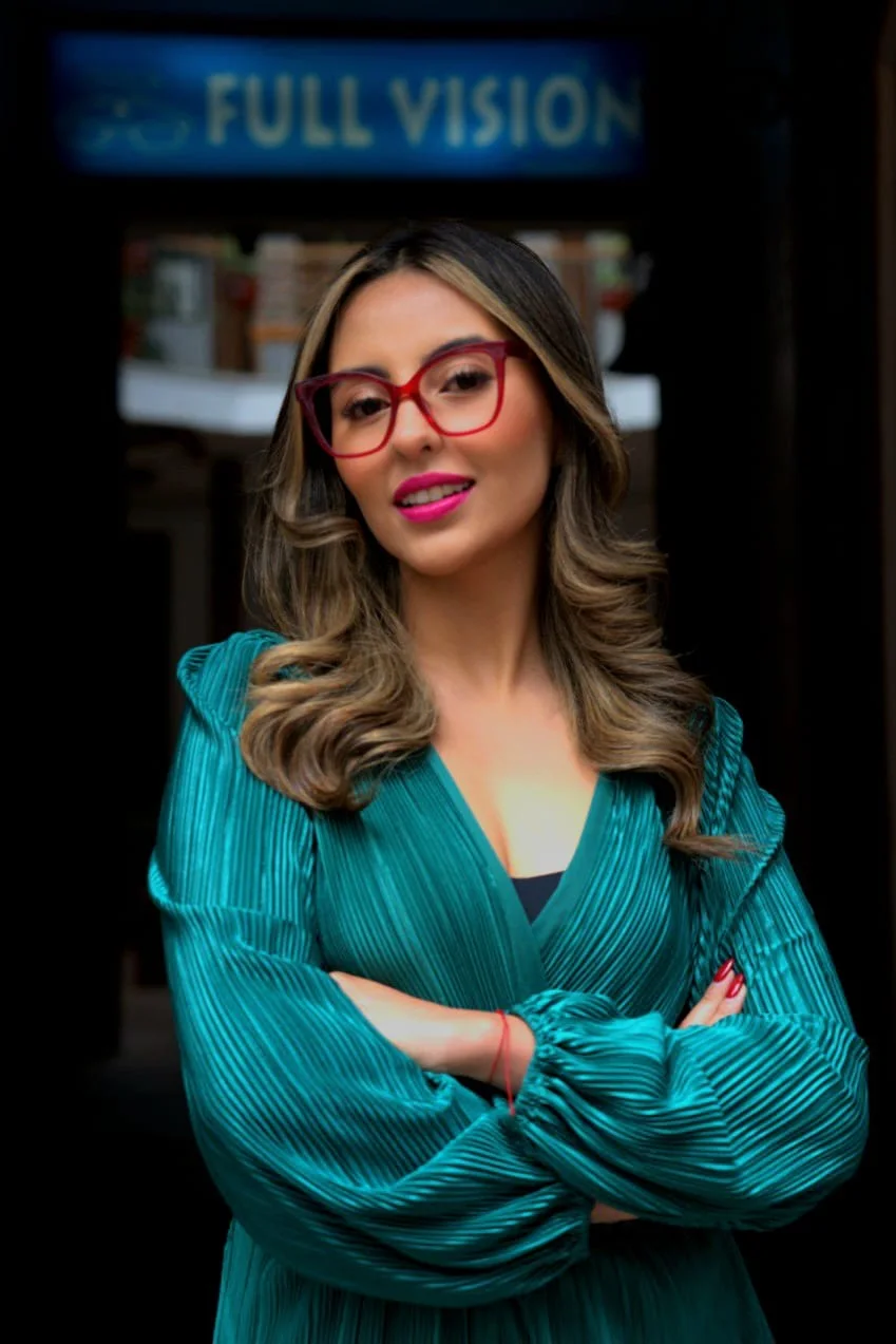 Clienta con gafas graduadas rojas frente al local